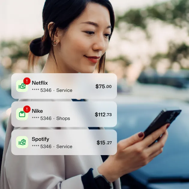 Woman looking at phone. Aura UI showing transactions with Netflix flagged as over limit. 